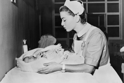 Black and White Image of Nurse Cooing Over a Newborn Baby. 